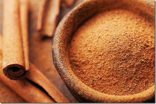 Powder cinnamon and sticks and on brown rustic background. Aromatic spices.